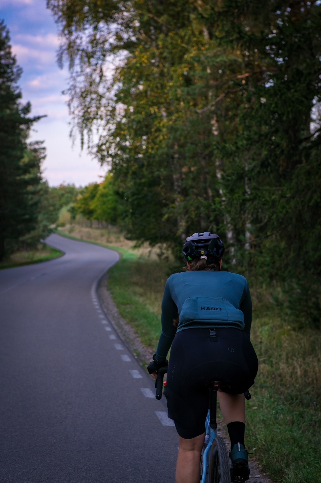 Rowerzystka na krętej drodze w mazurskim lesie podczas wyjazdu z Mazurskiego Raju