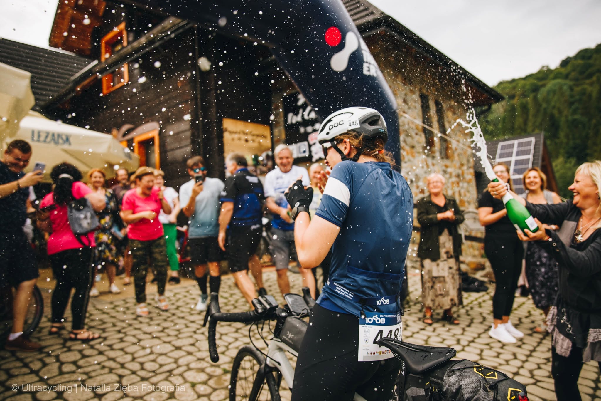 Weronika z rowerem na mecie Bałtyk–Bieszczady Tour, wśród kibicujących uczestników i ekipy